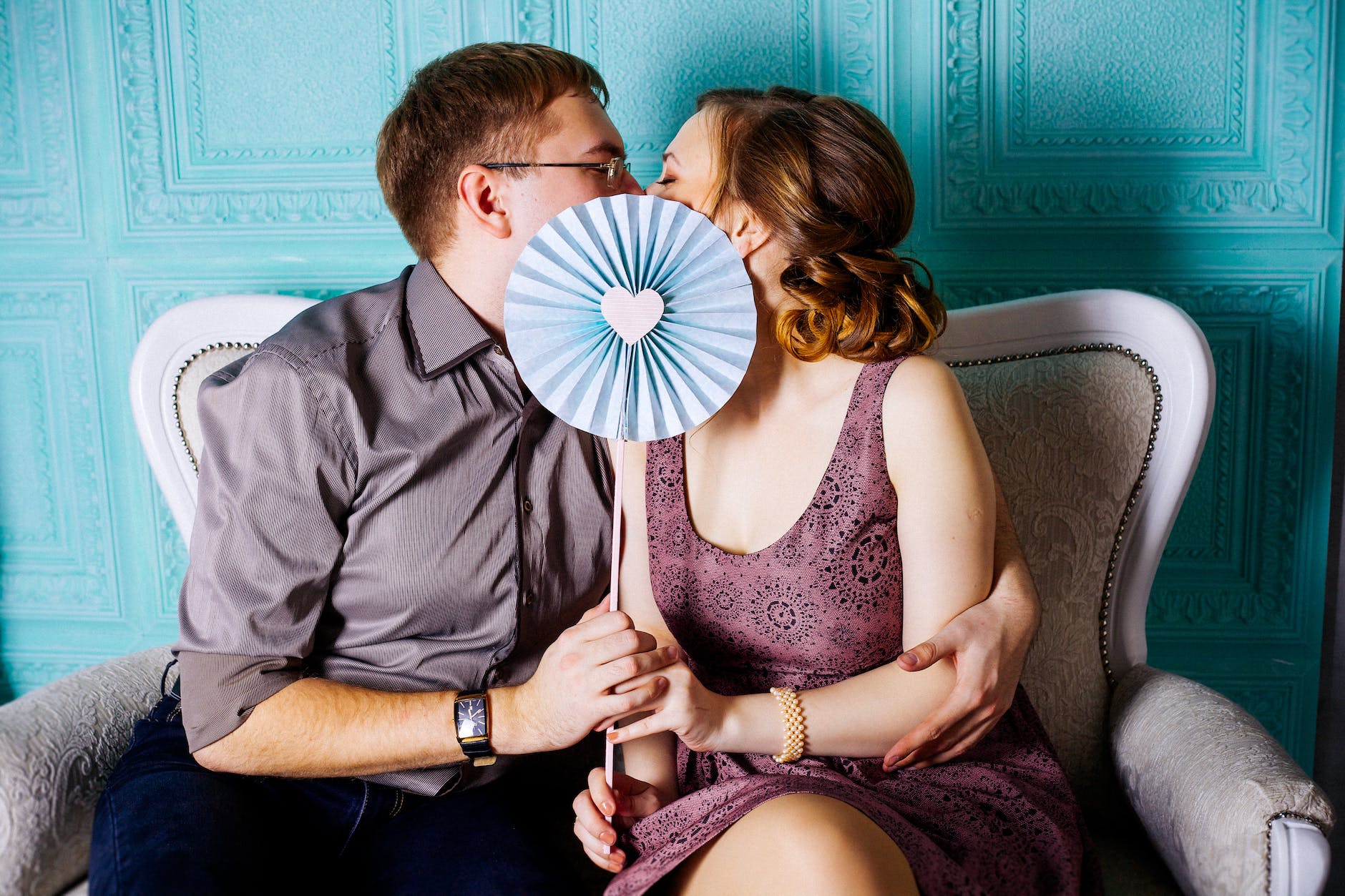 woman and man sitting on grey suede loveseat