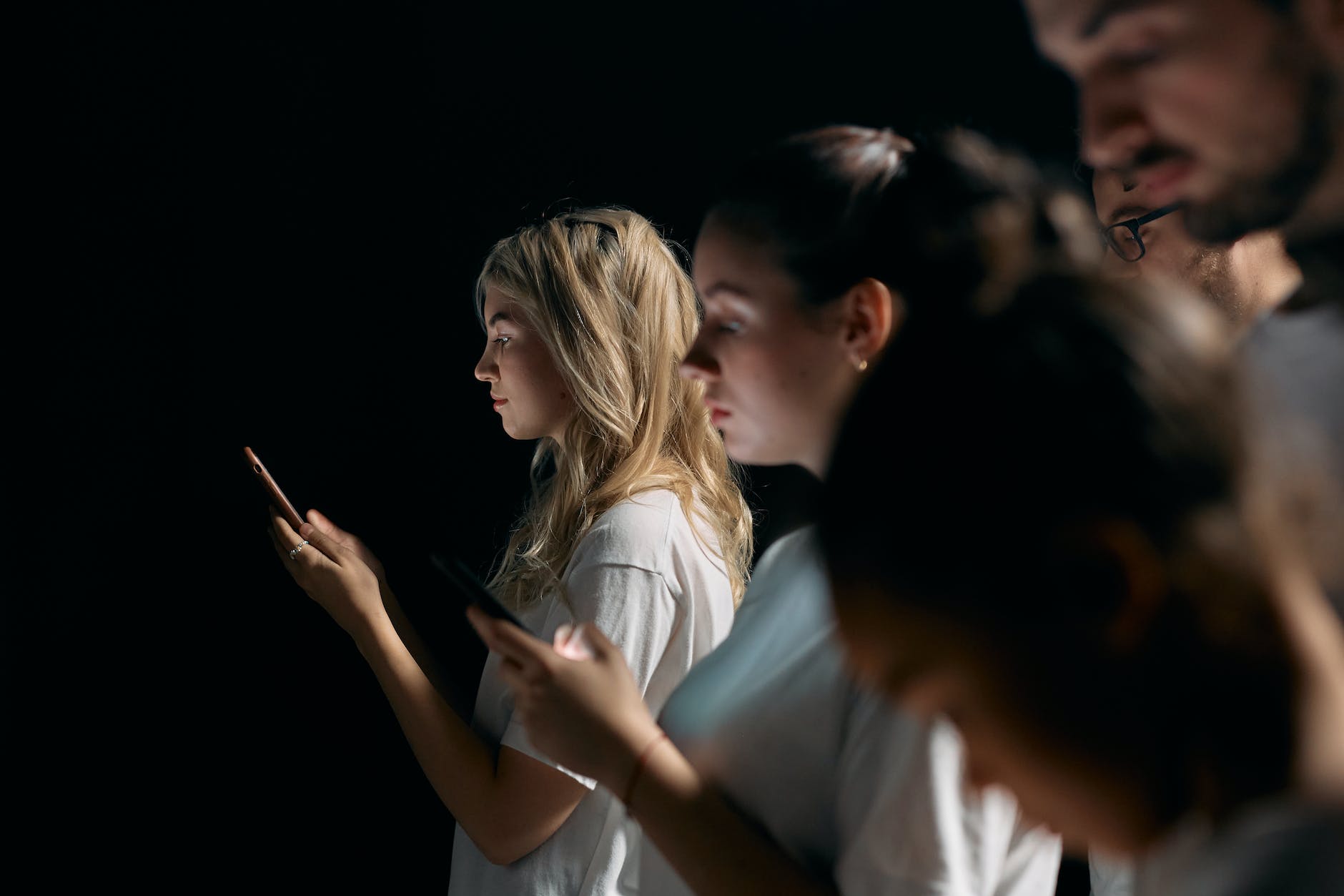 photo of woman in white shirt holding smartphone